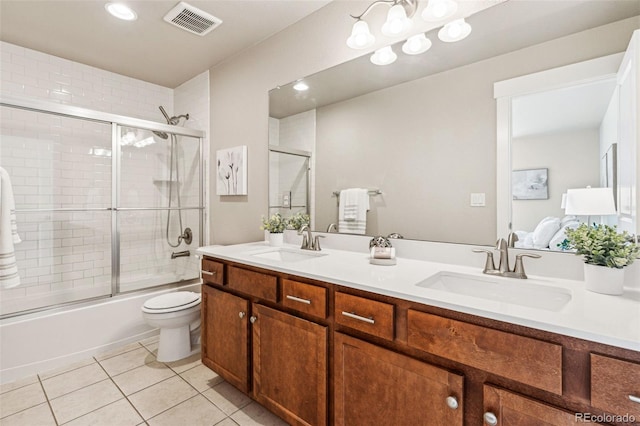 full bathroom with toilet, tile patterned floors, bath / shower combo with glass door, and vanity