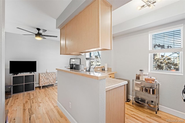 kitchen with ceiling fan, light wood-type flooring, light brown cabinetry, and kitchen peninsula