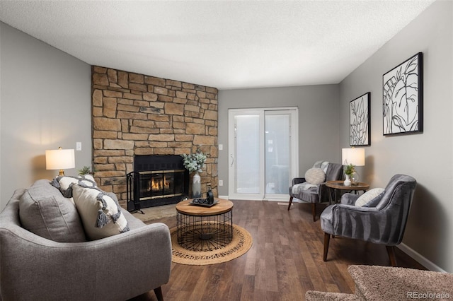 living room with hardwood / wood-style floors, a fireplace, and a textured ceiling