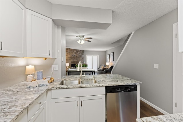 kitchen featuring stainless steel dishwasher, kitchen peninsula, white cabinetry, and sink