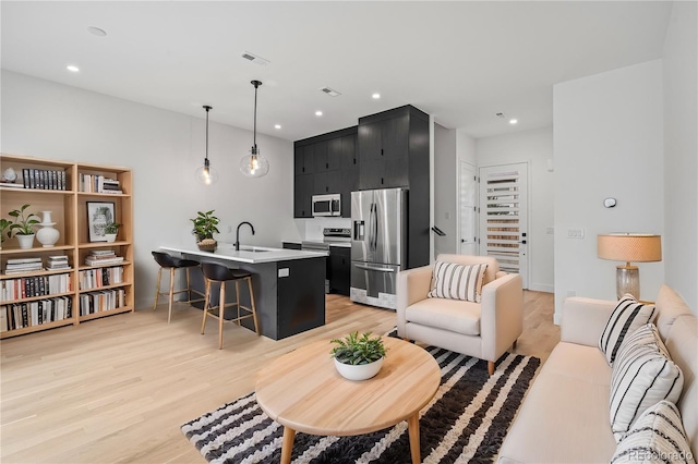 living room featuring recessed lighting, visible vents, and light wood finished floors