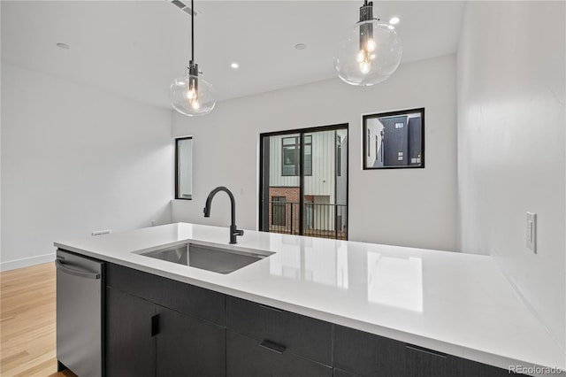 kitchen featuring light countertops, a sink, and decorative light fixtures