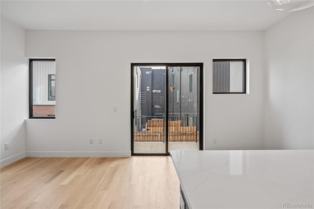 empty room with light wood-type flooring and baseboards