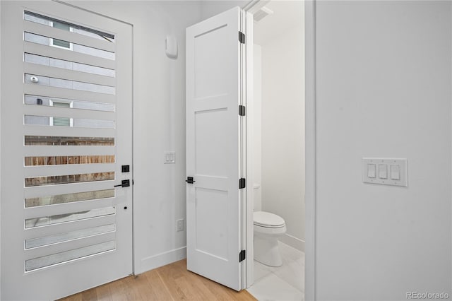 bathroom featuring toilet, baseboards, and wood finished floors