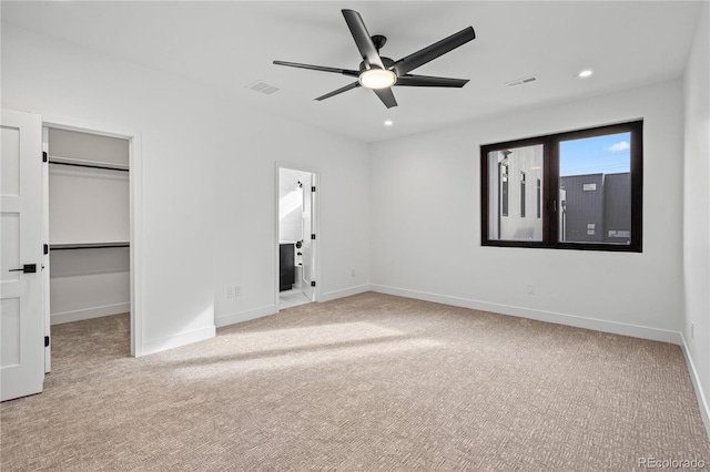 unfurnished bedroom featuring recessed lighting, a walk in closet, visible vents, and baseboards