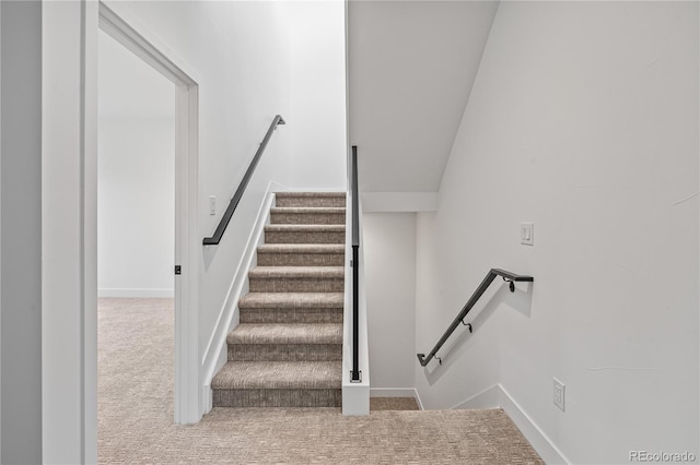 stairway featuring carpet floors and baseboards