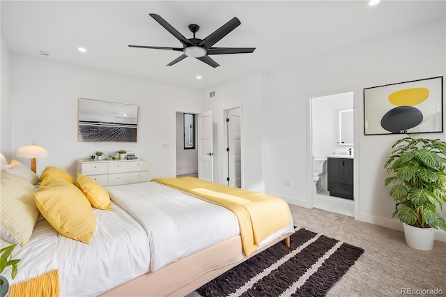 bedroom with ceiling fan, recessed lighting, light colored carpet, baseboards, and ensuite bath