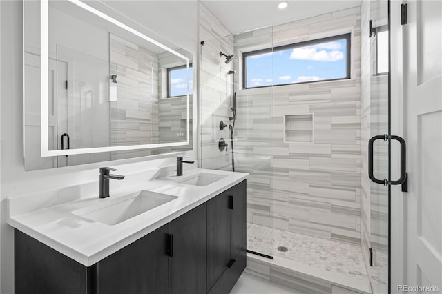 full bath featuring a stall shower, a sink, and double vanity