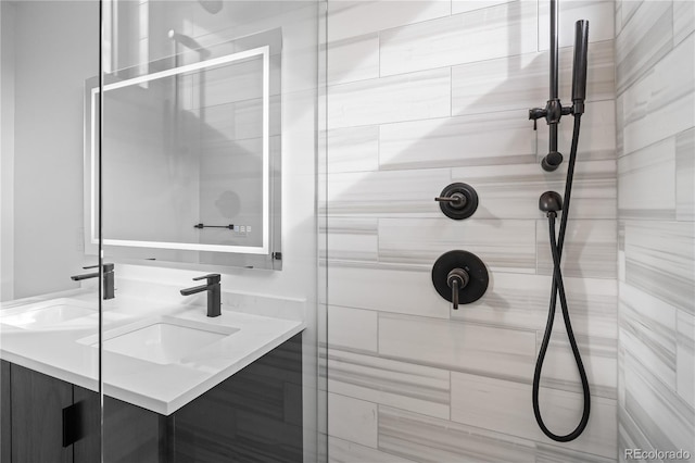 bathroom with a tile shower and vanity