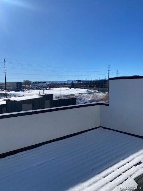 view of snow covered back of property