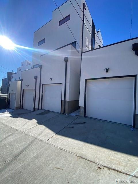 exterior space with a garage, driveway, and stucco siding