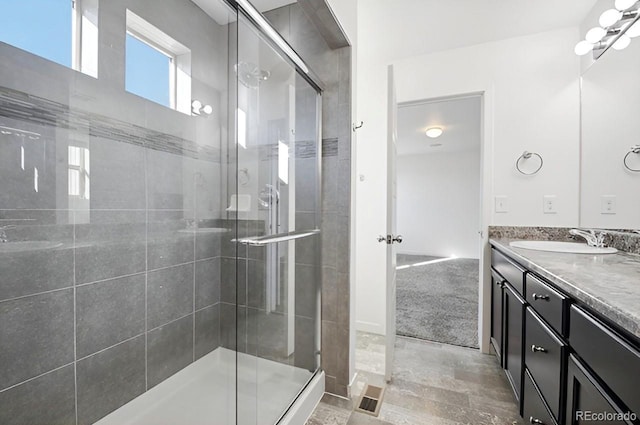 bathroom featuring vanity and a shower with door