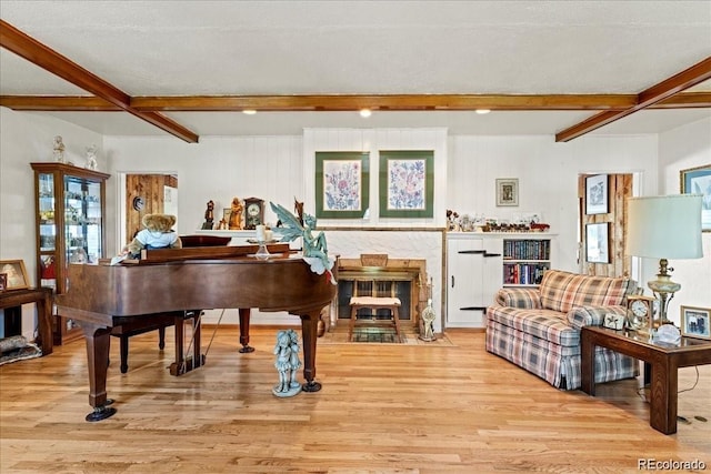 7750 W 5th Ave, Lakewood, CO 80226 - living room featuring beam ceiling, light wood-type flooring, a fireplace with flush hearth, and healthy amount of natural light