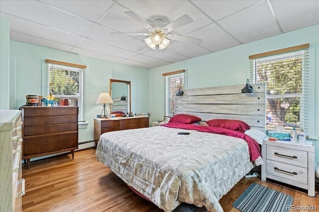 7750 W 5th Ave, Lakewood, CO 80226 - bedroom with light wood-style flooring, a baseboard radiator, and a ceiling fan