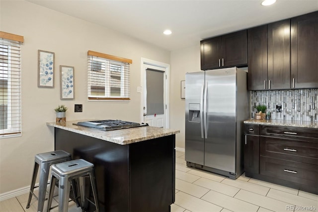 kitchen featuring a breakfast bar area, kitchen peninsula, a healthy amount of sunlight, and appliances with stainless steel finishes