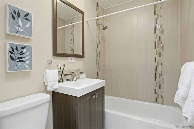 full bathroom featuring vanity, tiled shower / bath combo, and toilet