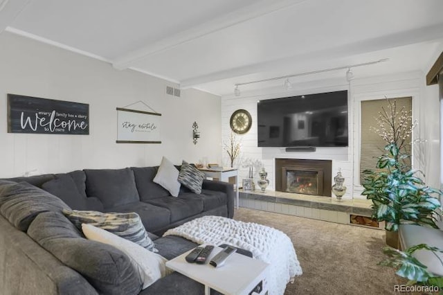 living area featuring carpet flooring, a fireplace, rail lighting, and visible vents