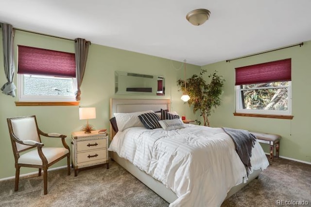carpeted bedroom featuring baseboards and multiple windows