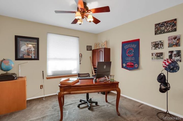 carpeted office space featuring baseboards and ceiling fan
