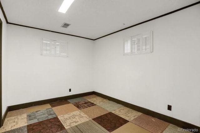 unfurnished room featuring visible vents, baseboards, and crown molding