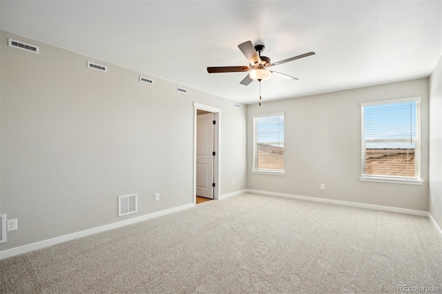 unfurnished room with light colored carpet, ceiling fan, and visible vents