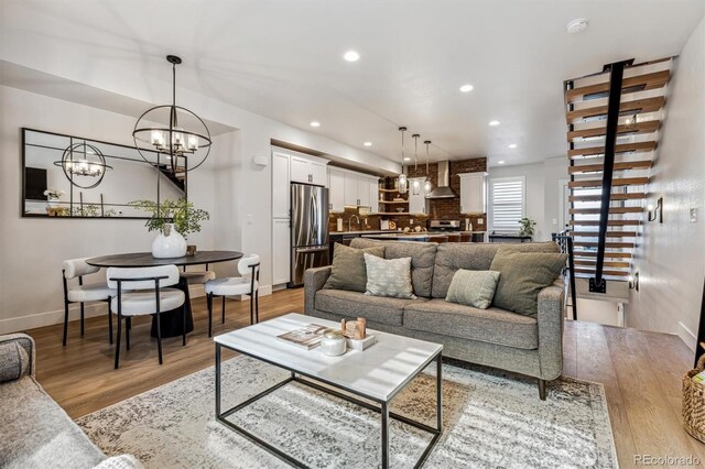 living area with light wood-style flooring, baseboards, and recessed lighting