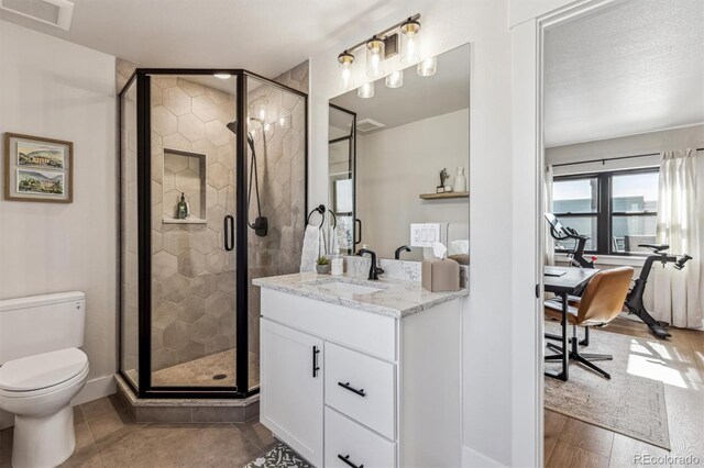 full bathroom featuring toilet, a stall shower, vanity, and visible vents