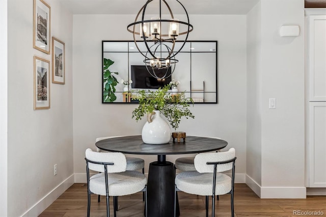 5423 S Prince St Unit B, Littleton, CO 80120 - dining room featuring a chandelier, baseboards, and wood finished floors