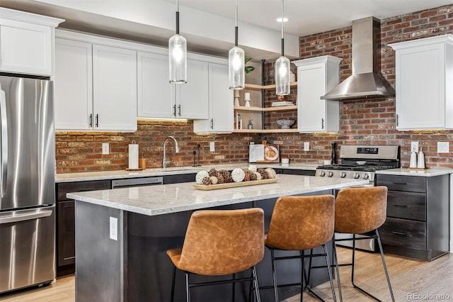 5423 S Prince St Unit B, Littleton, CO 80120 - kitchen featuring appliances with stainless steel finishes, wall chimney range hood, a center island, a sink, and open shelves
