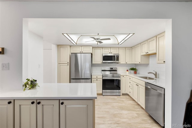 14300 E Marina Dr Unit 306, Aurora, CO 80014 - kitchen featuring appliances with stainless steel finishes, cream cabinets, ceiling fan, a peninsula, and light countertops