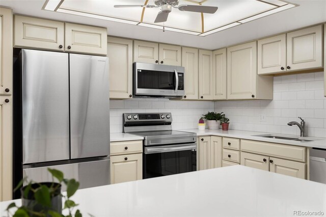 14300 E Marina Dr Unit 306, Aurora, CO 80014 - kitchen with stainless steel appliances, cream cabinets, light countertops, a ceiling fan, and tasteful backsplash
