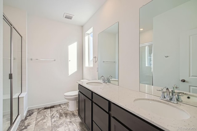 bathroom with a shower with door, vanity, and toilet