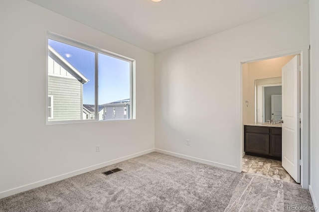 spare room featuring sink and light carpet