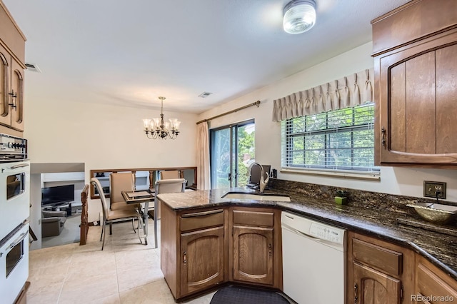 3724 S Poplar St, Denver, CO 80237 - kitchen with white appliances, a chandelier, pendant lighting, light tile patterned flooring, and dark stone countertops