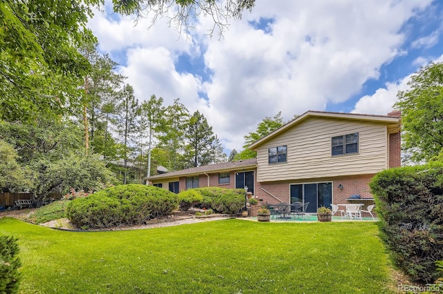 3724 S Poplar St, Denver, CO 80237 - back of property with brick siding, a patio, a lawn, and a chimney