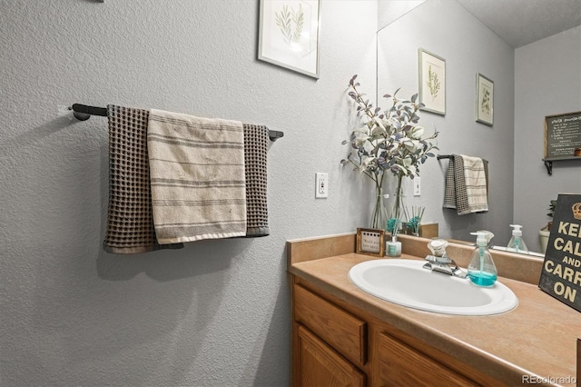 bathroom featuring vanity and a textured wall
