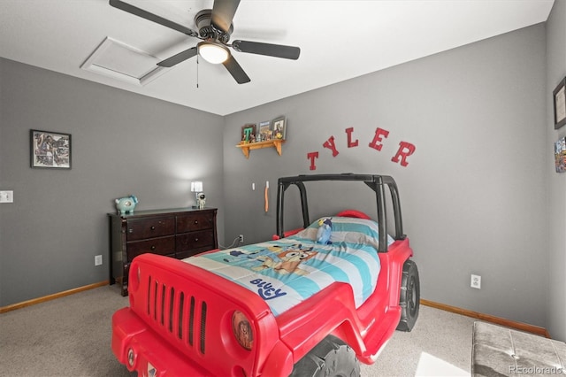 carpeted bedroom featuring baseboards, attic access, and a ceiling fan