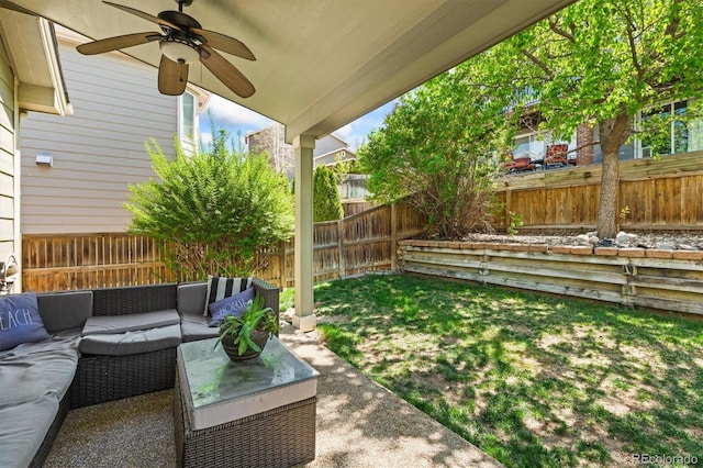 fenced backyard with an outdoor living space, ceiling fan, and a patio area