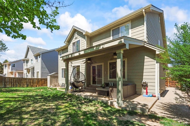 back of property featuring a ceiling fan, a patio, a storage unit, and an outbuilding
