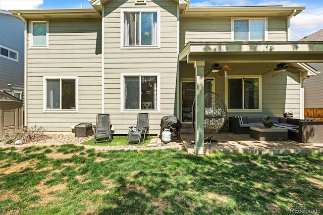back of property featuring ceiling fan, an outdoor living space, a lawn, and a patio area