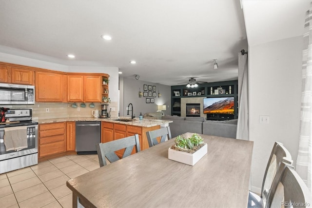 kitchen with appliances with stainless steel finishes, a sink, light tile patterned floors, a ceiling fan, and recessed lighting