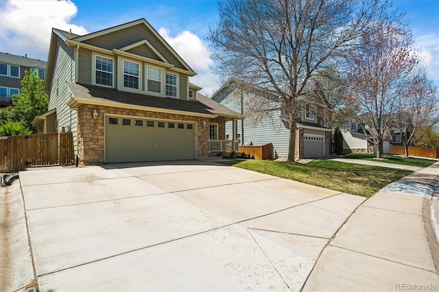 view of front of house featuring a garage, concrete driveway, fence, and stone siding