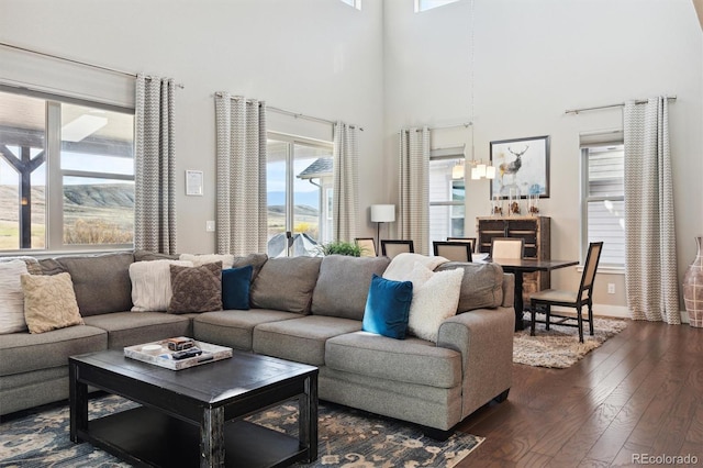 living room featuring dark wood-type flooring and a high ceiling