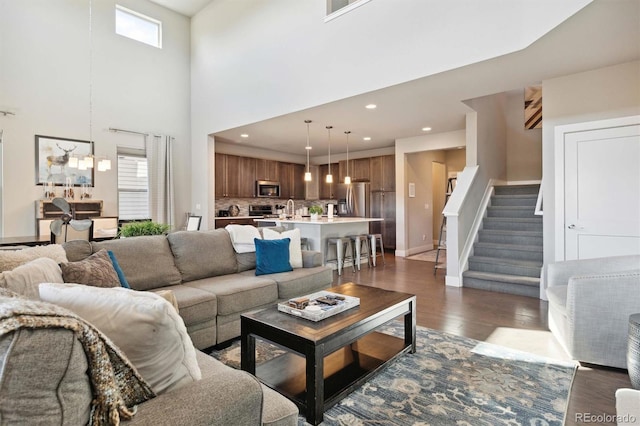 living room with a high ceiling and dark hardwood / wood-style floors