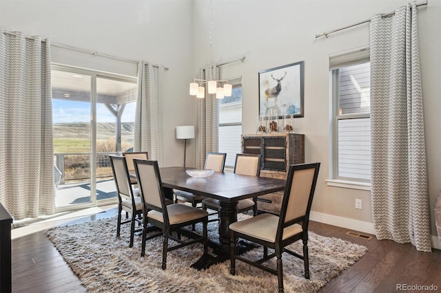 dining room featuring a notable chandelier and dark wood-type flooring