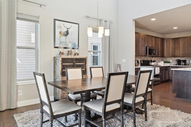 dining room with dark wood-type flooring and an inviting chandelier