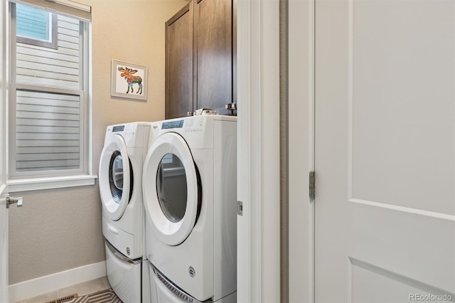 laundry room featuring cabinets and washer and clothes dryer