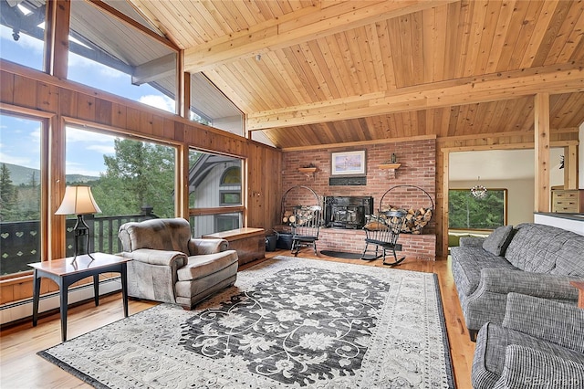 living room with lofted ceiling with beams, wood ceiling, light hardwood / wood-style floors, a brick fireplace, and brick wall