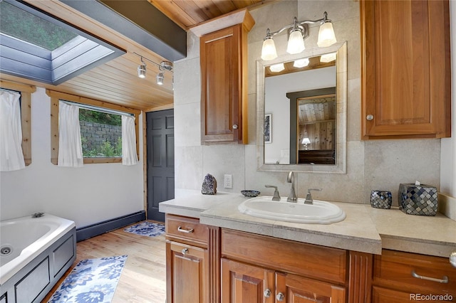 bathroom featuring a skylight, wood ceiling, vanity, a tub, and wood-type flooring