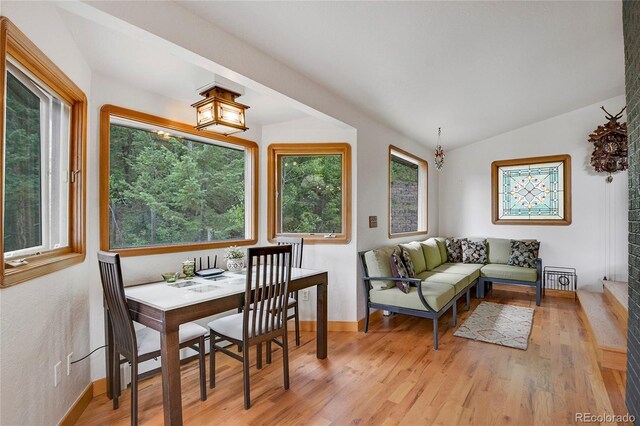 dining space featuring lofted ceiling and light wood-type flooring